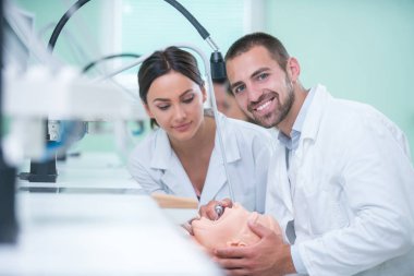 Takma diş, ağız hijyeni. Takma diş, takma diş, bir çalışma ve diş araçları içeren bir tablo üzerinde çalışırken protez eller.