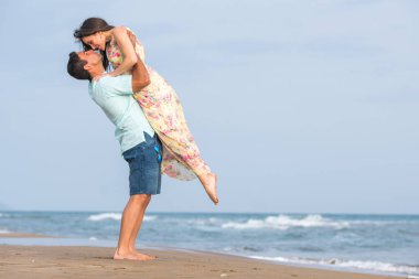 Kumsalda yürüyen çift.