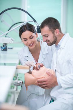 Takma diş, ağız hijyeni. Takma diş, takma diş, bir çalışma ve diş araçları içeren bir tablo üzerinde çalışırken protez eller.