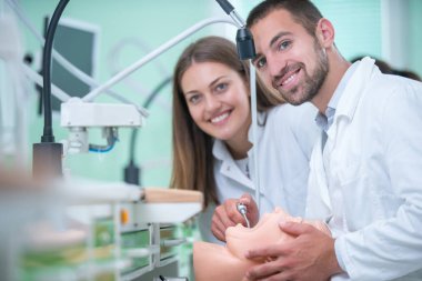 Takma diş, ağız hijyeni. Takma diş, takma diş, bir çalışma ve diş araçları içeren bir tablo üzerinde çalışırken protez eller.