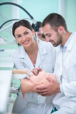 Takma diş, ağız hijyeni. Takma diş, takma diş, bir çalışma ve diş araçları içeren bir tablo üzerinde çalışırken protez eller.