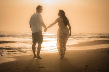 Kumsalda yürüyen çift.