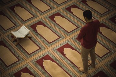 Dindar Müslüman adam caminin içinde dua ediyor.