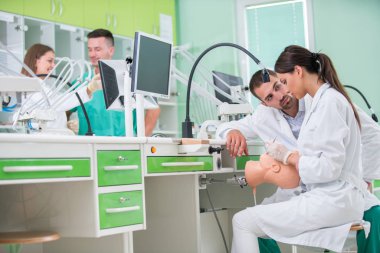 Takma diş, ağız hijyeni. Takma diş, takma diş, bir çalışma ve diş araçları içeren bir tablo üzerinde çalışırken protez eller.