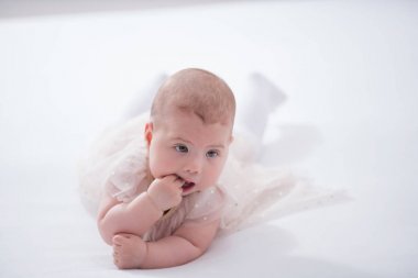 Odasındaki yatakta emekleyen bir bebeğin portresi.