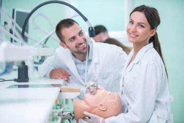 Takma diş, ağız hijyeni. Takma diş, takma diş, bir çalışma ve diş araçları içeren bir tablo üzerinde çalışırken protez eller.