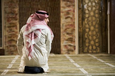 Dindar Müslüman adam caminin içinde dua ediyor.