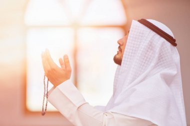 Dindar Müslüman adam caminin içinde dua ediyor.