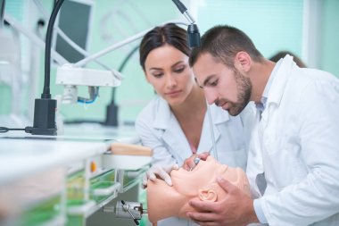 Takma diş, ağız hijyeni. Takma diş, takma diş, bir çalışma ve diş araçları içeren bir tablo üzerinde çalışırken protez eller.