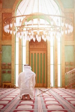 Dindar Müslüman adam caminin içinde dua ediyor.