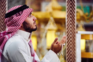 Dindar Müslüman adam caminin içinde dua ediyor.