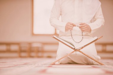 Dindar Müslüman adam caminin içinde dua ediyor.