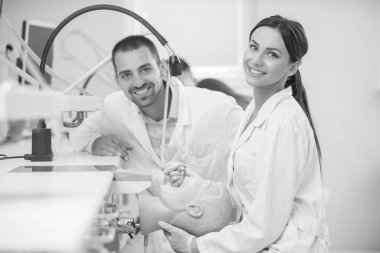 Takma diş, ağız hijyeni. Takma diş, takma diş, bir çalışma ve diş araçları içeren bir tablo üzerinde çalışırken protez eller.