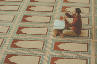 Dindar Müslüman adam caminin içinde dua ediyor.