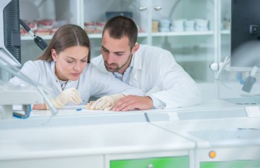 Takma diş, ağız hijyeni. Takma diş, takma diş, bir çalışma ve diş araçları içeren bir tablo üzerinde çalışırken protez eller.