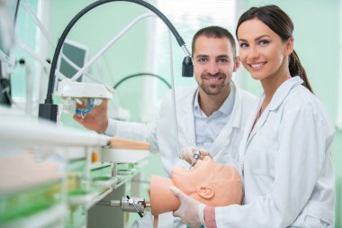 Takma diş, ağız hijyeni. Takma diş, takma diş, bir çalışma ve diş araçları içeren bir tablo üzerinde çalışırken protez eller.