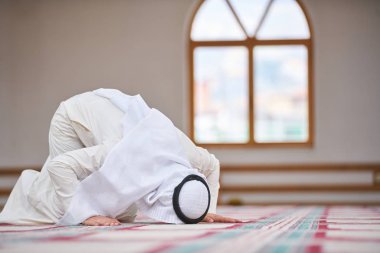 Dindar Müslüman adam caminin içinde dua ediyor.