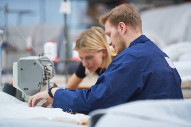 Terzi bir tekstil fabrikasında bir makineye atanan yeni, ustabaşı bir şey açıklar