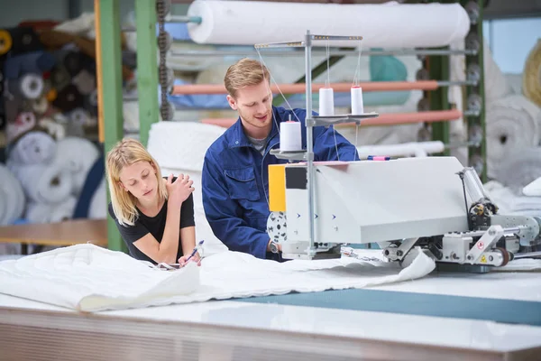 裁缝是新分配给一台机器在纺织厂 工头解释的东西 — 图库照片