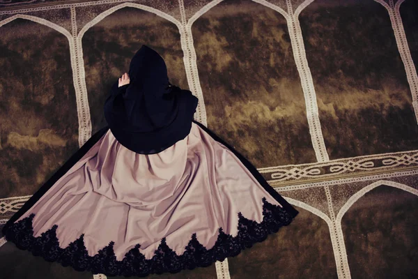 Young muslim woman praying in mosque