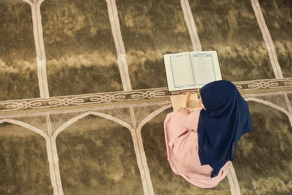 Young muslim woman praying in mosque