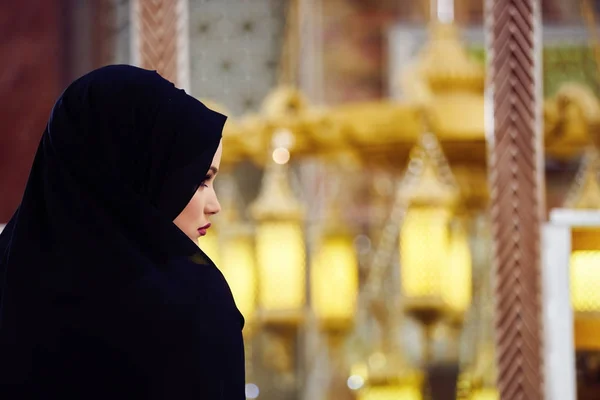 Young muslim woman praying in mosque