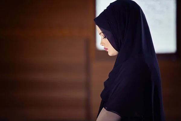 Young muslim woman praying in mosque