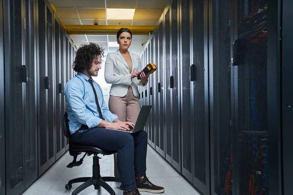 two young technicians working at a data center on server maintenance