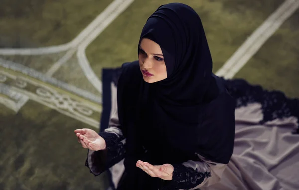 Young muslim woman praying in mosque