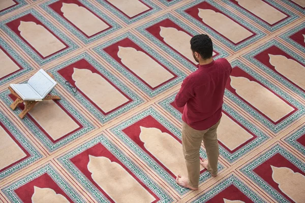 Dindar Müslüman adam caminin içinde dua ediyor.