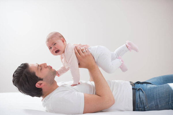 Молодой отец играет со своим малышом
