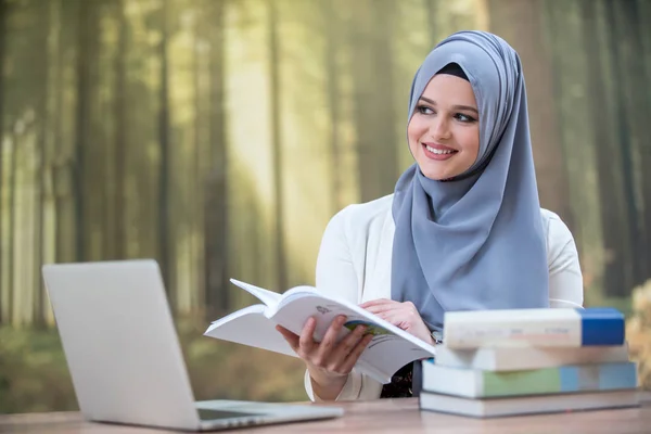 Pretty woman wearing hijab in front of laptop search and studying
