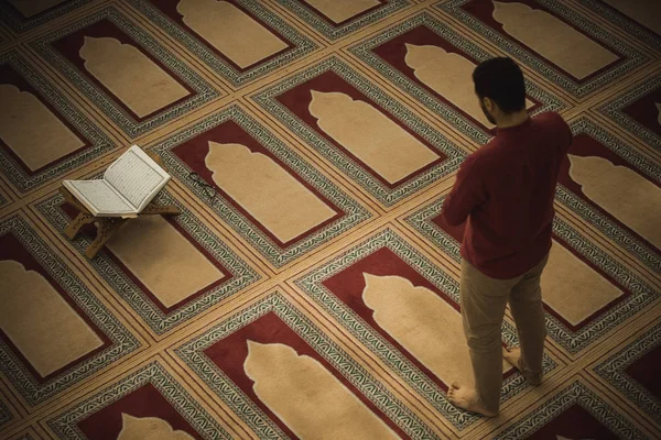 Dindar Müslüman adam caminin içinde dua ediyor.