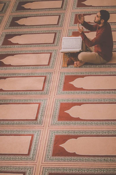 Dindar Müslüman adam caminin içinde dua ediyor.