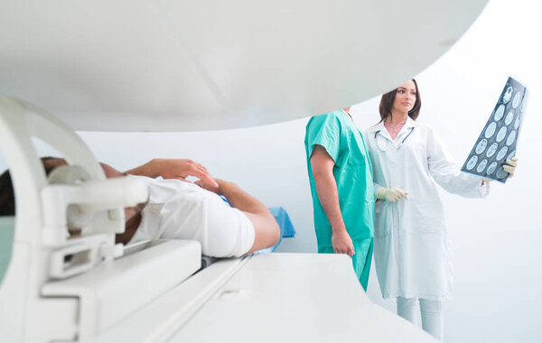 Confident pleasant doctor working with MRI scan results