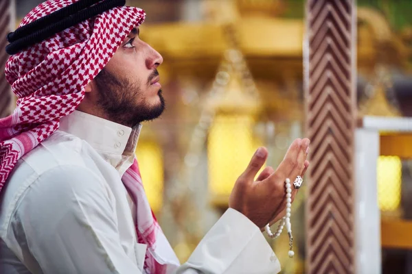 Dindar Müslüman adam caminin içinde dua ediyor.