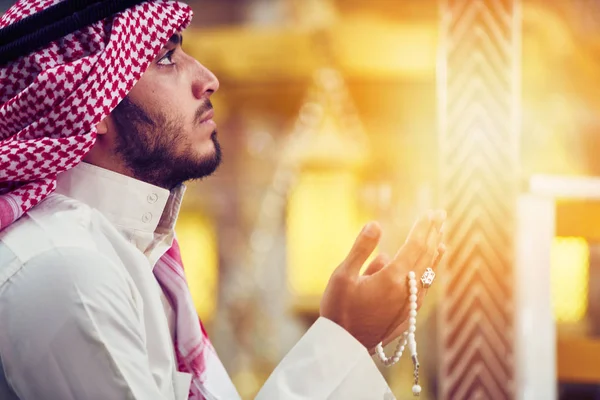 Dindar Müslüman adam caminin içinde dua ediyor.