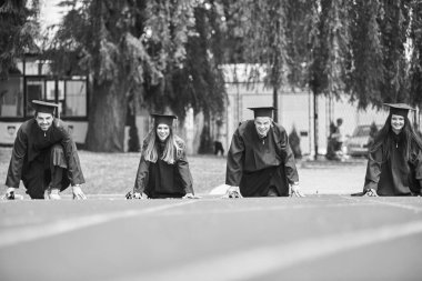 Eğitim, mezuniyet ve halk konsepti. Havan topu ve diplomalı bekarlık elbisesi giyen bir grup mutlu uluslararası öğrenci.