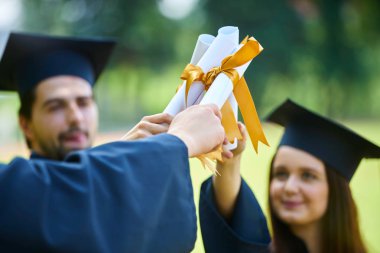 Eğitim, mezuniyet ve halk konsepti. Havan topu ve diplomalı bekarlık elbisesi giyen bir grup mutlu uluslararası öğrenci.