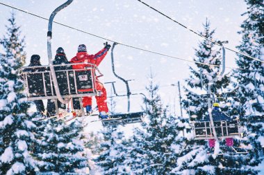Kayakçı ve snowboard üzerinde bir teleferik