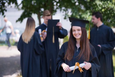 Eğitim, mezuniyet ve halk konsepti. Havan topu ve diplomalı bekarlık elbisesi giyen bir grup mutlu uluslararası öğrenci.