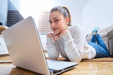 yerde yatarken ve dizüstü kullanan kadın