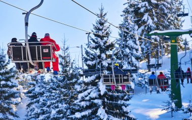 Kayakçı ve snowboard üzerinde bir teleferik