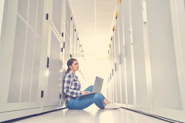 female technician working on server maintenance in white server room