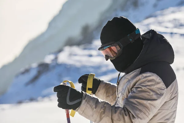 Ski touring man reaching the top at sunrise in Swiss Alps.