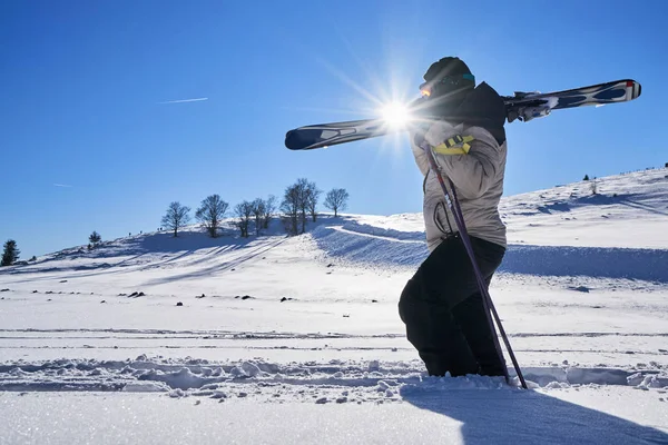 Ski touring man reaching the top at sunrise in Swiss Alps.