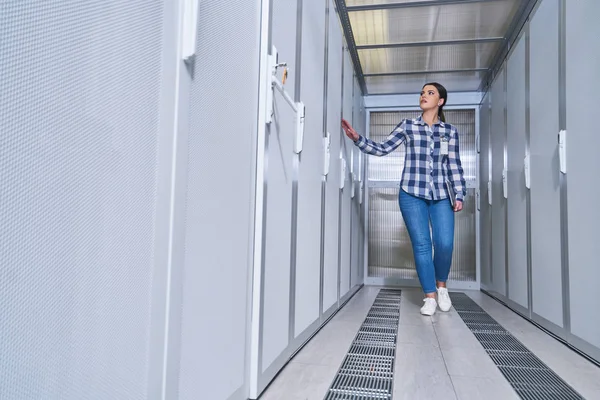 female technician working on server maintenance in white server room