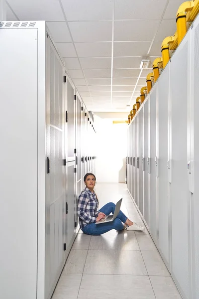 female technician working on server maintenance in white server room