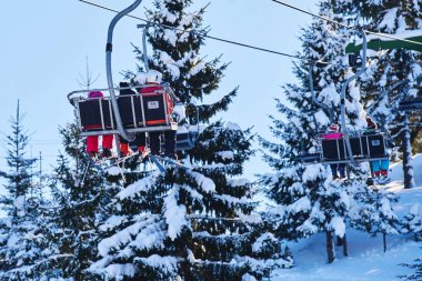 Kayakçı ve snowboard üzerinde bir teleferik
