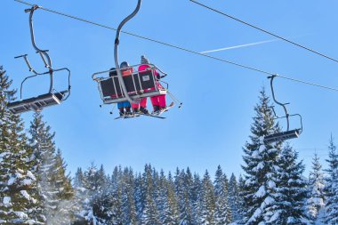 Kayakçı ve snowboard üzerinde bir teleferik